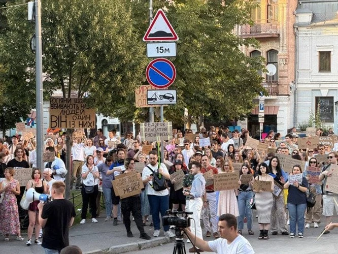 Учасники мирних мітингів у містах України тримають плакати на підтримку Михайла Федорова